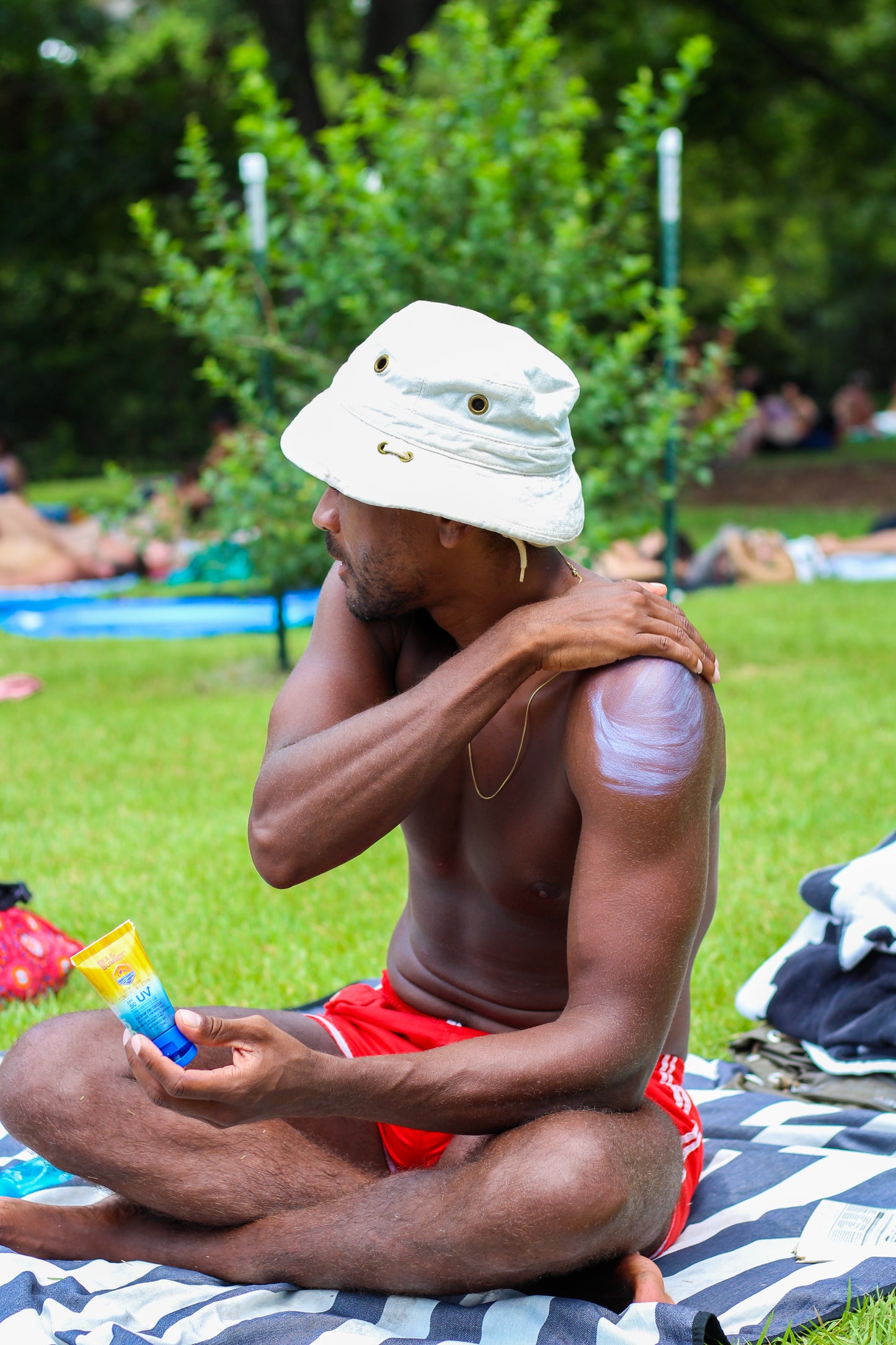 Sea & Summit Sunscreen's SPF 50 body lotion being applied at the park during summer.