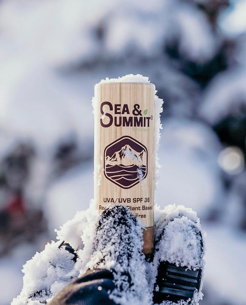 Sea & Summit's organic SPF 36 face stick held up in a snowy winter background.