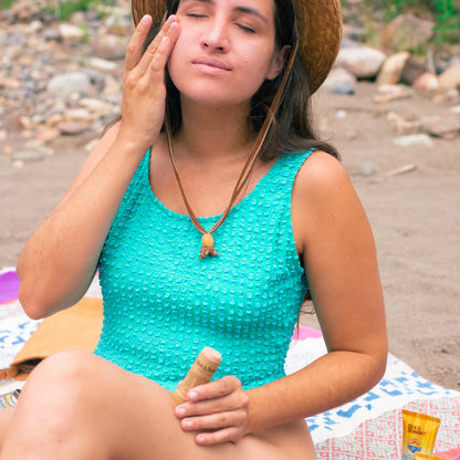 Kat applying the tinted SPF 50 Tan Mineral face stick on a day at the beach.