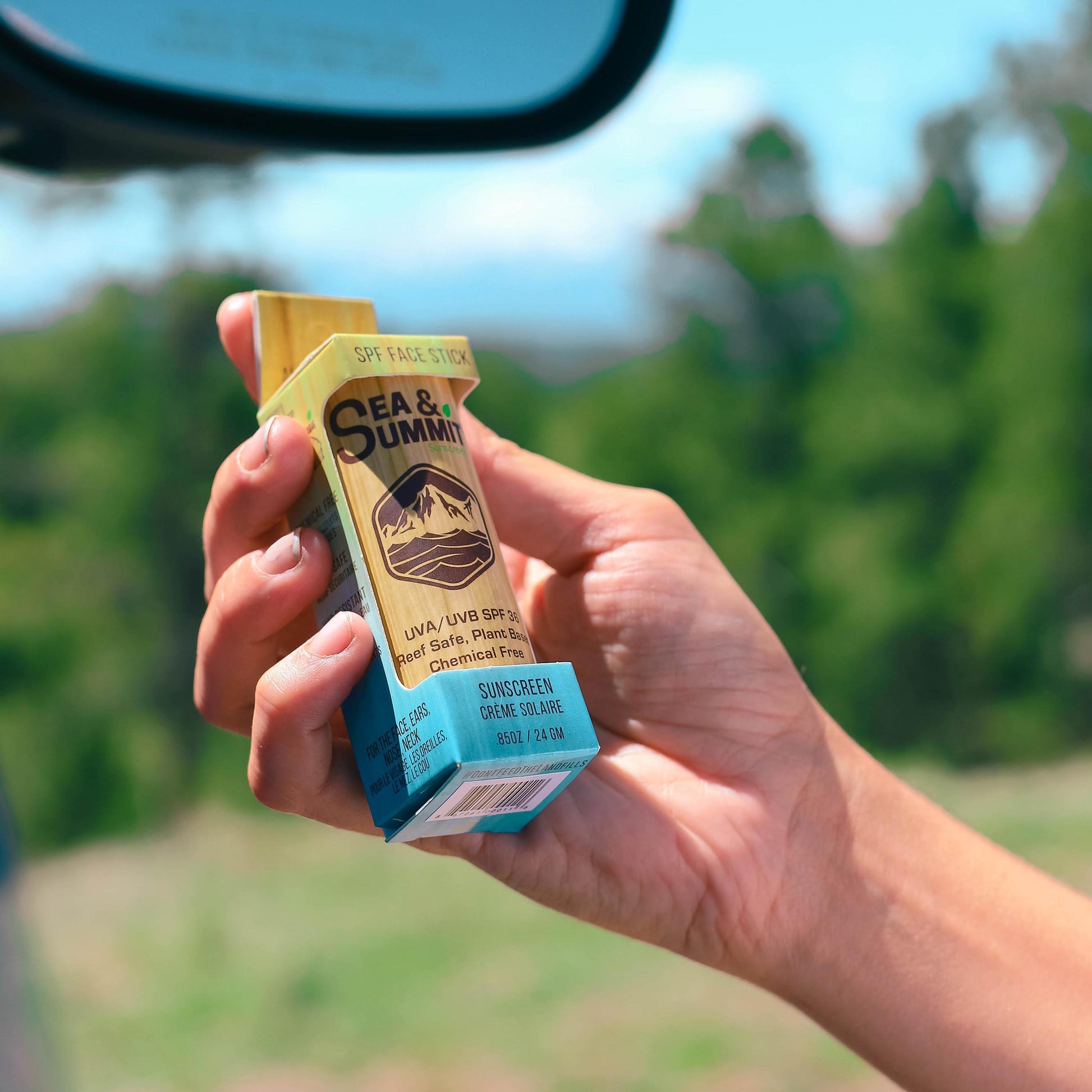 Dalton holding up the full SPF 36 face stick in its recyclable packaging on one of his summer road trips.
